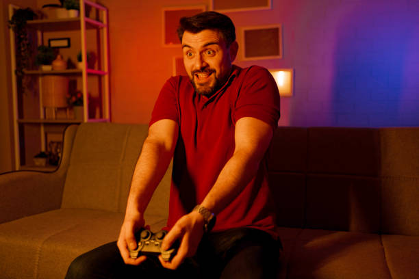 istock Man holding a joystick and playing video games 2199560332