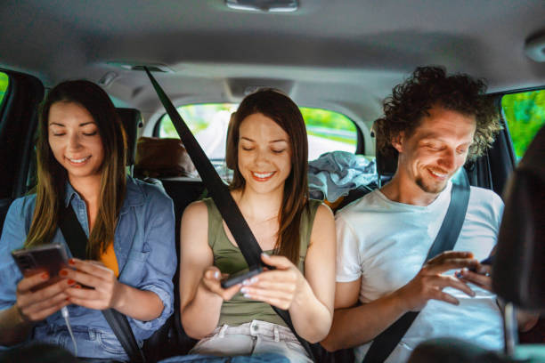 istock Three young adults using smartphones while traveling by car 2199560627