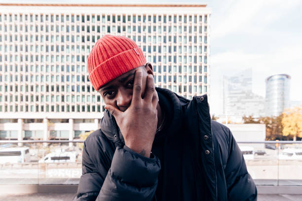 istock Man wearing a red beanie and dark coat in an urban setting 2199562628