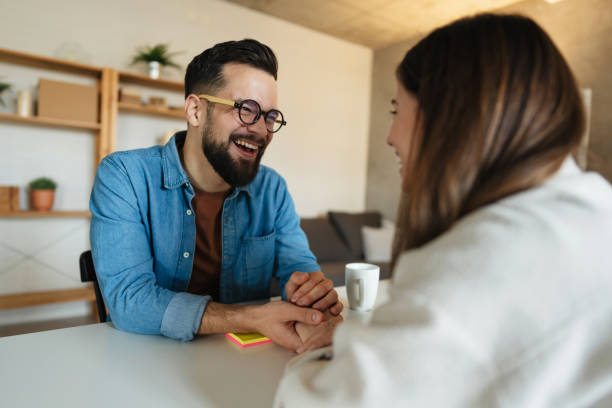 istock Young couple holding hands and laughing at home 2199565439