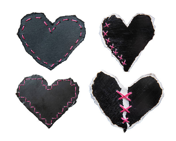 Black heart-shaped torn papers with pink stitches