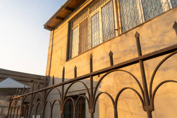 istock Rustic Metal Fence and Sunlit Building 2199566324