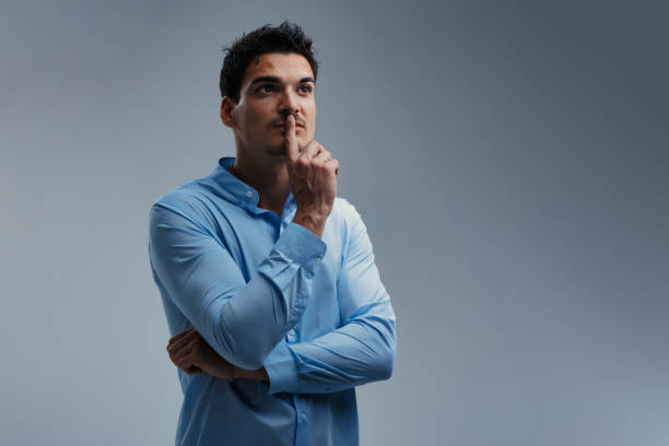istock Pensive businessman is thinking with finger on lips looking up 2199568009