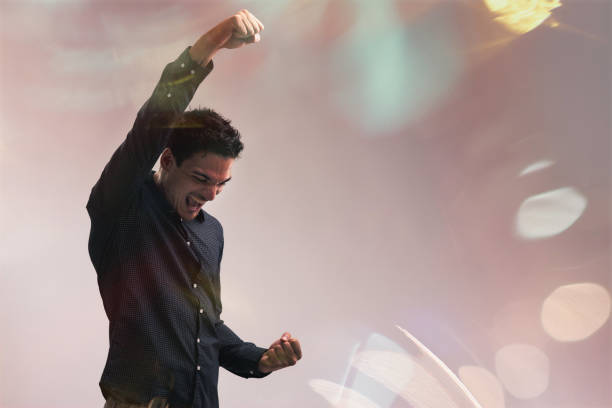 腕を上げ、握りこぶしで成功を祝う若いビジネスマン - 活力 ストックフォトと画像