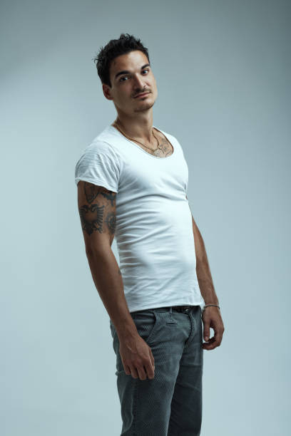 istock Portrait of young male model posing in studio with tattoos 2199568225