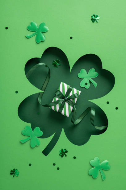 istock Green vertical shamrock cutout with decorative elements, featuring a small striped gift box displayed 2199569527