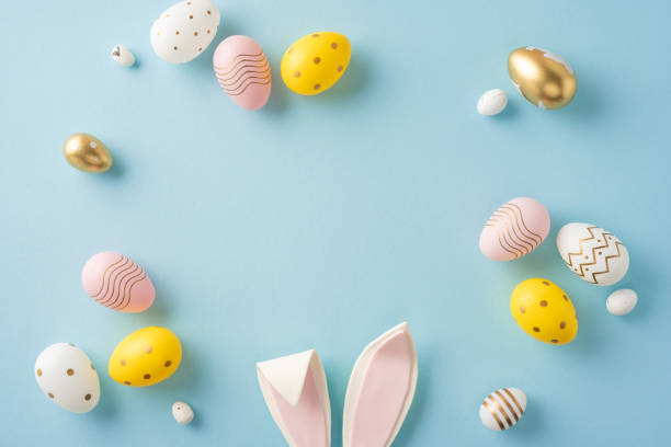 istock Easter-themed arrangement of colorful decorative eggs and bunny ears displayed on a pastel surface 2199569540