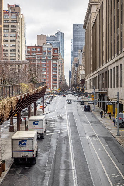 The High Line, Manhattan, New York, United States - January 11th 2025:  High angle view to 30th Street with industry buildings and parked trucks on a cold winter day