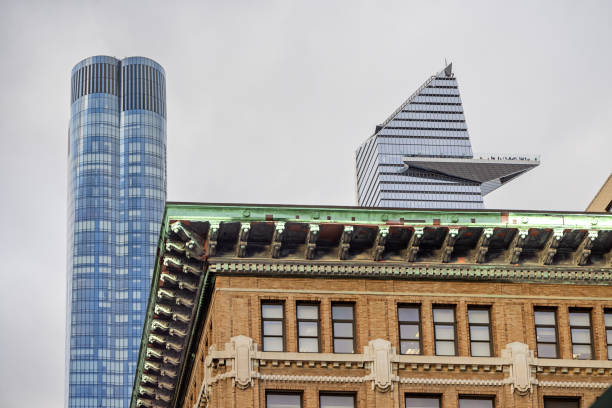 The High Line, Manhattan, New York, United States - January 11th 2025:  Details of American architecture from two periods, in front an classic brown stone building and behind the modern high rise skyscrapers at Hudson Yard