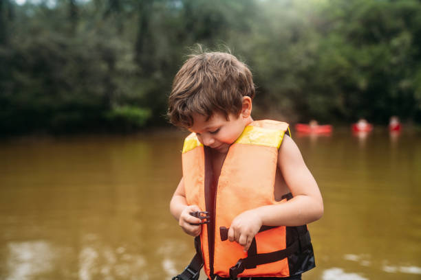 istock Boy putting safety Jacket at the lake 2199571481