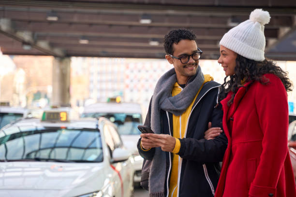 istock Young couple ordering taxi using mobile app in city 2199571696