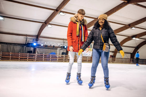 istock Friends having fun ice skating together 2199571904