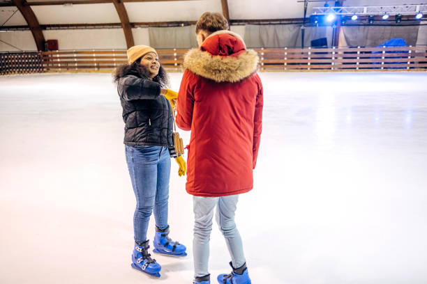 istock Friends having fun ice skating together 2199571972