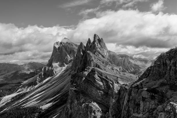 istock Black and white panoramic capture of the Seceda ridge in the Dolomites, Italy, emphasizing the sharp rock formations, rugged textures, and contrasting light and shadows 2199576400