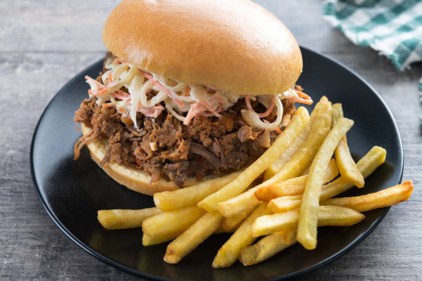 istock Pulled pork sandwich with coleslaw salad on wooden table 2199576704