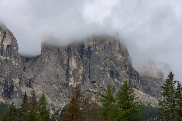 istock Fog drapes the Dolomite summits, partially obscuring the steep cliffs and the narrow cascade of the Pisciadu waterfall 2199576725