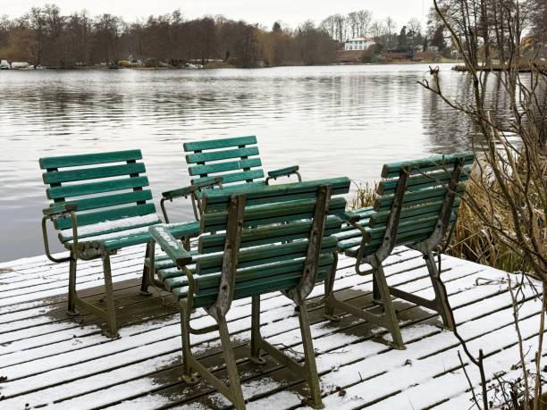 Stunning real estate feature showcasing four chairs on a snow-covered jetty with breathtaking views of a serene lake. This winter scene highlights the potential for relaxation and outdoor enjoyment in a prime property location. The tranquil setting offers a perfect spot to unwind, with nature’s beauty as a backdrop for luxurious living.