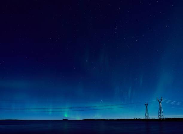 istock Northern lights over a tranquil lake with power lines. 2199577791