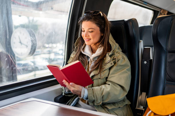 istock Female passenger reading book while traveling by train 2199582176