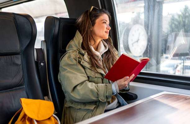 istock Female passenger reading book while traveling by train 2199582275