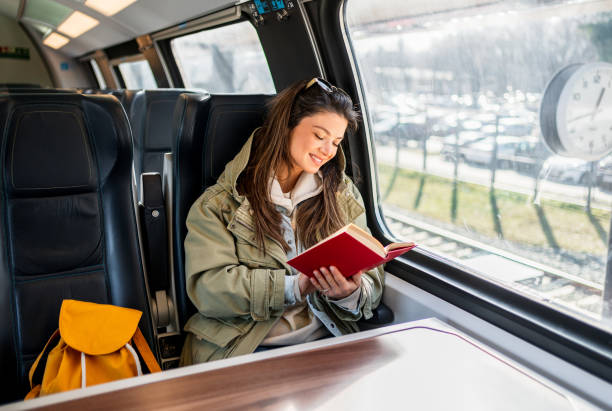 istock Woman reading a book while traveling by train 2199582286