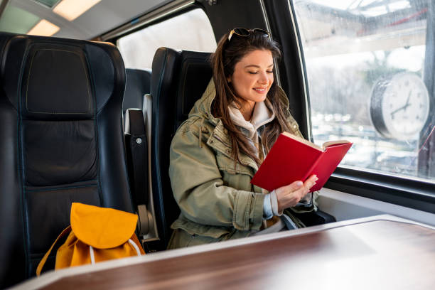 istock Female passenger reading book while traveling by train 2199582468