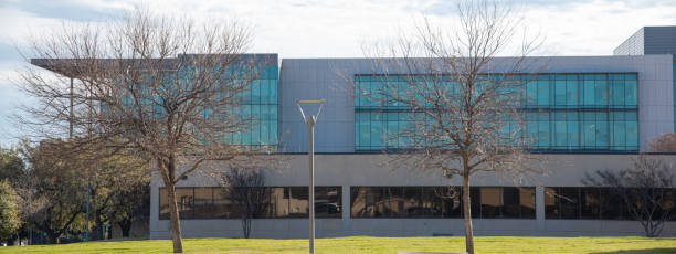 istock Panorama view modern campus building complex university college students in Dallas, Texas, sunny cloud winter sky, well-trimmed yard landscape, metal fence, sidewalk pathway, education industry 2199582688