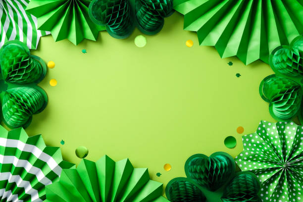 istock Happy St Patrick's Day banner design. Flat lay green paper decorations, including honeycomb shamrocks and fans on a green background. Top view with space for text. 2199584023