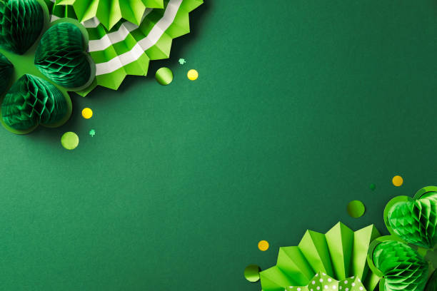 istock Green St. Patrick's Day background with paper decorations, including shamrocks and rosettes, on a green backdrop. Flat lay, top view, copy space. 2199584091