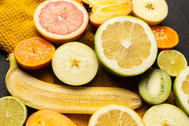 istock A bunch of fruit including bananas, oranges, kiwis, and grapefruit. The fruit is cut up and arranged on a table 2199587511