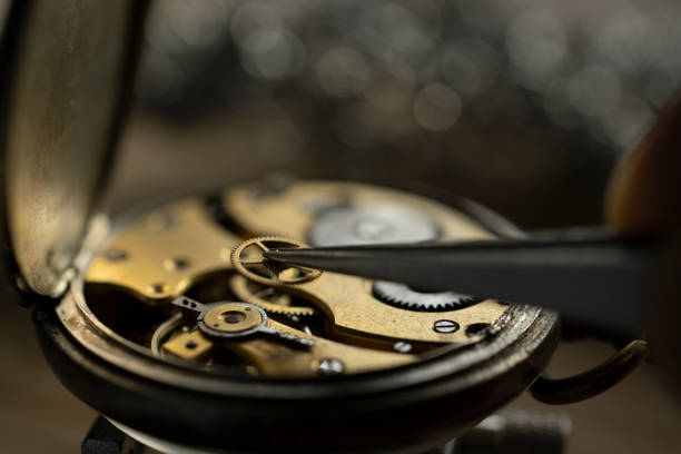 istock Professional watchmaker repairer working on an old vintage pocket watch in a workshop. 2199589691