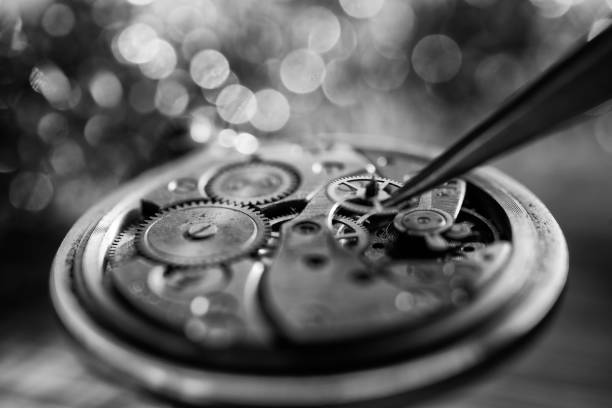 Professional watchmaker repairer working on an old vintage pocket watch in a workshop.