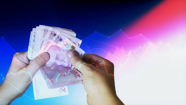 Human hands counting 200 and 100 TL banknotes on financial chart background, It can be used for concepts such as economy, finance, trading, country economies (Depth Of Field)