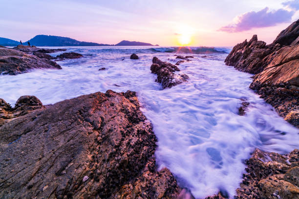 Long exposure image of Dramatic sky seascape with rock in sunset scenery background