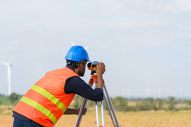 istock A young engineer is looking through a survey camera to level the area for road construction in a wind power generating area. 2199592386