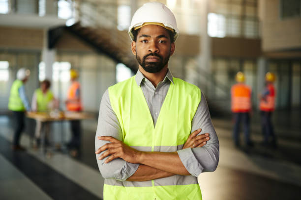 istock Portrait of serious black engineer with crossed arms. 2199601598