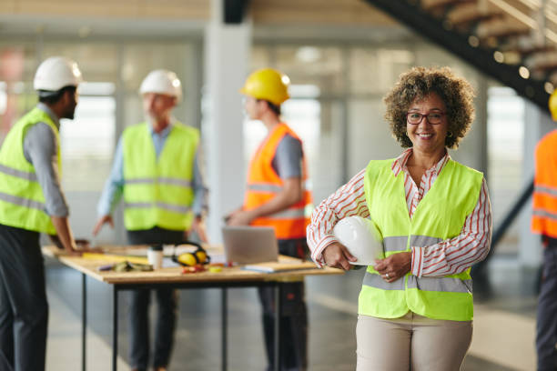 istock Happy female project manager in front of her colleagues at construction site. 2199603788