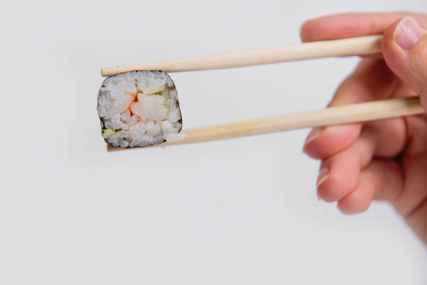 Maki sushi roll filled with salmon and crab stick, elegantly served with soy sauce on a black background
