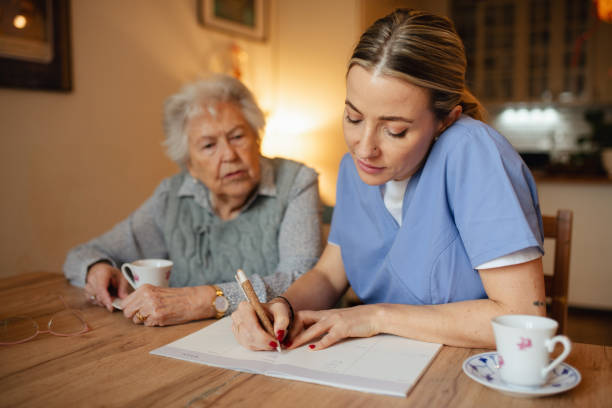 istock Social worker helping elderly lady with managing her finances, working on financial plan. 2199605571