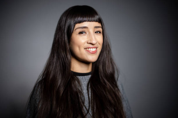 istock Close-up of woman with bangs looking at camera and smiling 2199609318