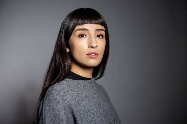 istock Studio portrait of woman with bangs and neutral expression in gray sweater 2199609319