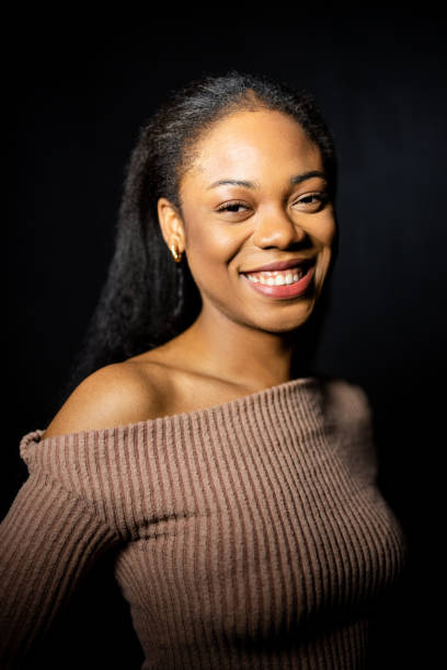 istock Confident young African woman in studio against black background 2199609332