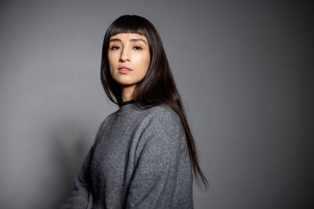 istock Woman model with bangs in gray sweater against gray background 2199609365