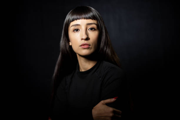 istock Thoughtful young Latin woman against dark background 2199609399