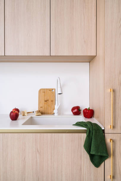 istock Modern kitchen sink setup with red peppers and cutting board on countertop 2199612910