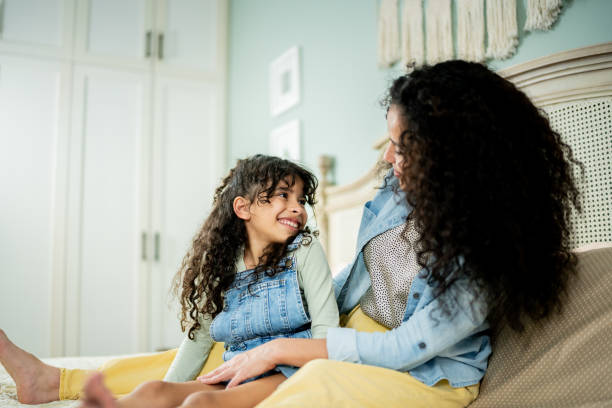 istock Mother and daughter talking on bedroom at home 2199613484