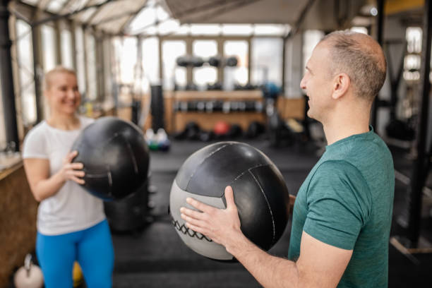 istock Energetic workout session in gym with partners using medicine balls for strength training and fitness goals 2199617185