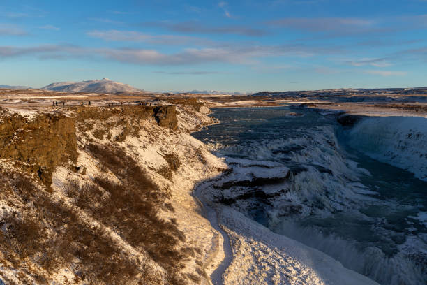 The Gullfoss Waterfall on the Icelandic Golden Circle Tour. Photographed in November 2024. Shot in daytime with blue, cloudy sky.