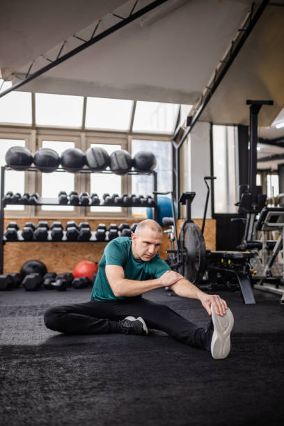 istock Focused adult practicing flexibility and stretching routines in a gym environment promoting health and fitness 2199619813