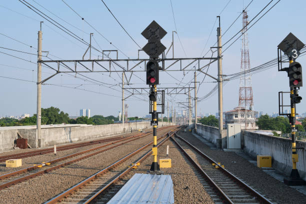 istock Railway Tracks with Red Traffic Signals and Overhead Power Lines 2199620083